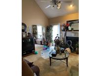Cozy living room featuring a ceiling fan, a fireplace, and various decorative items at 413 W Wind Dr, Villa Rica, GA 30180