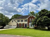 Traditional two-story home featuring a brick and siding exterior, three-car garage, and a well-manicured front lawn at 881 Park Manor Nw Ct, Marietta, GA 30064