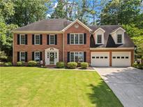 Charming two-story brick home featuring manicured lawn and attached two-car garage at 4961 Thornwood Nw Trce, Acworth, GA 30102