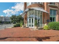 Brick building entrance featuring double glass doors, manicured greenery, and a covered awning with visible signage at 325 E Paces Ferry Ne Rd # 1910, Atlanta, GA 30305
