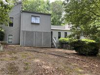 Two-story home featuring neutral siding, a lattice privacy screen and partially wooded front yard at 3090 Alberta Dr, Marietta, GA 30062