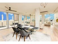 Bright dining area with modern table and chairs, opens to balcony with stunning city views and living area at 1280 W Peachtree Nw St # 4003, Atlanta, GA 30309