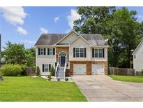 Charming two-story home with stone accents, well-maintained lawn, and a two-car garage at 2140 Hurt Sw Rd, Marietta, GA 30008