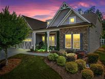 Charming home featuring stone and shingle accents, a well-manicured lawn, and a cozy covered porch at 105 Laurel Canyon Trl, Canton, GA 30114