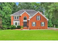 Charming two-story brick home with a well-manicured lawn and mature trees at 2071 Habersham Cir, Covington, GA 30014