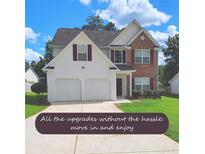 Charming two-story home with a well-maintained lawn, two-car garage, and a mix of brick and siding exterior at 5050 Roxton Ln, Douglasville, GA 30135