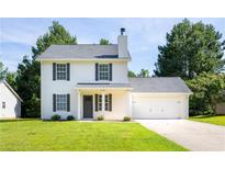 Charming two-story home features a symmetrical design with white siding and black shutters and an attached two-car garage at 5484 Denny Dr, Atlanta, GA 30349
