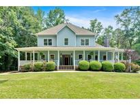 Charming two-story home featuring a welcoming wrap-around porch and well-manicured landscaping at 14 Black Forest Run, Douglasville, GA 30134