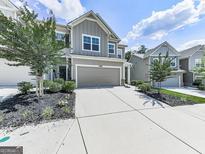 Inviting two-story home features a gray exterior, attached two-car garage, and well-maintained landscaping at 5512 Cascade Run, Atlanta, GA 30336