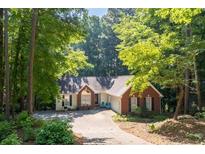 Charming home with brick and siding exterior, mature trees, and a welcoming front yard at 2030 Buford Dam Rd, Buford, GA 30518