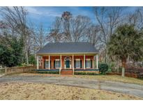 Charming brick home featuring a covered front porch, inviting curb appeal, and traditional architectural details at 1216 Valley Dr, Conyers, GA 30012