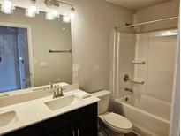 Bright bathroom featuring a double sink vanity, illuminated mirror, and a shower-tub combo with white tile surround at 305 Melanie Ct, Bowdon, GA 30108
