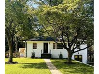 Charming white brick home with lush landscaping and inviting walkway at 661 Kennesaw Se Dr, Smyrna, GA 30080