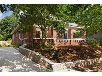 Charming brick home featuring a blue front door, landscaped yard, and inviting curb appeal at 19 Wyman Se St, Atlanta, GA 30317