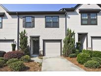 Charming townhome with a one-car garage and beautifully landscaped front yard at 6345 Mountain Home Se Way, Mableton, GA 30126