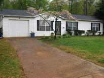 Charming single-story home with a well-manicured lawn and blossoming tree in the front yard at 218 Whispering Pine Circle Ne Cir, White, GA 30184