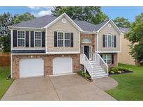 Charming split-level home featuring a brick facade, two-car garage, and welcoming front staircase at 4040 Brightmore Dr, Austell, GA 30106