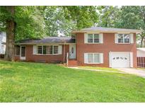 Charming two-story red brick home with white shutters and a well-manicured lawn at 1558 Boulderwoods Se Dr, Atlanta, GA 30316