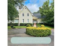 Elegant two-story home with lush landscaping and a circular driveway, exuding curb appeal and charm at 1417 Doe Valley Dr, Lithonia, GA 30058