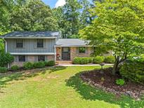 Charming two-story home with manicured front lawn, brick accents, and mature landscaping at 579 Chapman Dr, Marietta, GA 30066