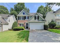 Charming two-story home featuring a brick and siding exterior with a well-manicured lawn and two-car garage at 335 Pintail Ct, Suwanee, GA 30024