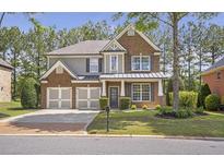 Charming two-story brick home with a three-car garage and well-manicured lawn at 4765 Silver Leaf Dr, Cumming, GA 30040