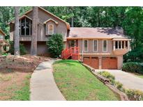 Charming two-story home with lush landscaping, attached garage, and wood accents at 4915 Millers Trce, Peachtree Corners, GA 30096