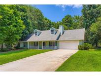 Charming single-Gathering home featuring a manicured lawn, two-car garage, and inviting front porch at 230 Belmont Trl, Covington, GA 30016
