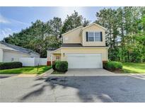 Charming two-story home with a two-car garage, manicured lawn and mature trees at 609 Bedford Court, Woodstock, GA 30188