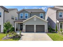 Charming two-story home with a two-car garage and beautifully landscaped front yard under a bright blue sky at 4583 Roskin St, Duluth, GA 30097