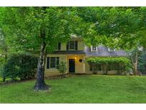Charming two-story home with lush green lawn and mature trees offering shade at 658 Slew Ave, Lawrenceville, GA 30043