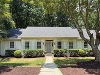 Charming single-story home with gray shutters and a well-manicured front yard with mature trees and shrubs at 1590 Sunnybrook Farm Rd, Atlanta, GA 30350