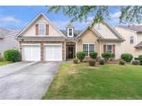Charming home featuring a well-manicured lawn, stone accents, two-car garage, and classic curb appeal at 918 Harvest Brook Dr, Lawrenceville, GA 30043