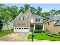 Charming two-story home featuring a brick facade, a two-car garage, and a well-maintained front yard at 507 Mirramont Pl, Woodstock, GA 30189