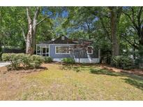 Charming single-story home featuring a screened front porch and lush, mature landscaping at 2130 Main Nw St, Atlanta, GA 30318
