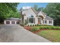 Charming stucco home with a three-car garage and meticulously maintained landscaping at 434 Westlake Nw Dr, Marietta, GA 30064