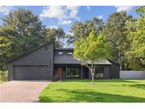 Contemporary home featuring a modern design, dark wood facade, manicured lawn, and attached two-car garage at 600 Applewood Nw Ln, Marietta, GA 30064