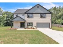 Charming two-story home featuring a painted brick exterior, inviting front porch, and attached two-car garage at 1128 E Shoreview Rd, Mcdonough, GA 30253