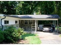 Charming home featuring a covered carport and stone facade with a well-maintained front yard at 6264 Godfrey Sw Dr, Mableton, GA 30126