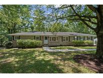 Charming brick ranch home with a well-manicured lawn, mature trees, and inviting walkway at 119 Walker Nw Rd, Cartersville, GA 30121