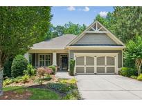 Charming single-story home with a well-manicured lawn, mature trees and a two car garage at 328 Shade Tree Cir, Woodstock, GA 30188