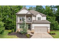 Charming two-story home features a welcoming front porch and a well-manicured lawn at 4814 Little Cove Ct, Auburn, GA 30011