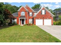 Charming brick two-story home featuring an attached two-car garage and well-manicured lawn at 5054 Kingsbridge Pass, Powder Springs, GA 30127