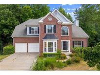 Charming two-story brick home with a well-manicured front yard and attached two car garage at 1413 Eastbrooke Way, Marietta, GA 30066
