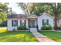 Charming single-story home featuring a manicured lawn and inviting front porch with updated door at 3143 Church St, East Point, GA 30344