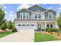 Charming two-story home with a well-manicured lawn, two-car garage, and stylish gray and white color scheme at 515 Cobblestone Ct, Canton, GA 30115