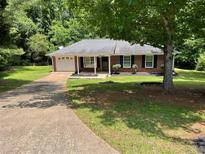 Charming single-story brick home featuring a well-maintained lawn and a paved driveway at 7400 Little Fawn Pkwy, Palmetto, GA 30268
