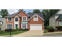 Beautiful brick home with manicured lawn, attached two car garage, and mature trees at 2905 Olde Town Park Dr, Norcross, GA 30071