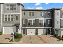 Attractive townhome exterior with a two-car garage, covered entry, and professionally landscaped front yard at 3014 Liberty Nw Way, Atlanta, GA 30318