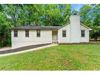 Charming single-story home with a brick chimney and a well-manicured lawn at 4110 Oak Ferry Ne Dr, Kennesaw, GA 30144
